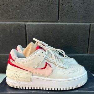 The Nike Air Force 1 Low Shadow Phantom W Phantom, Echo Pink, and Gym Red.